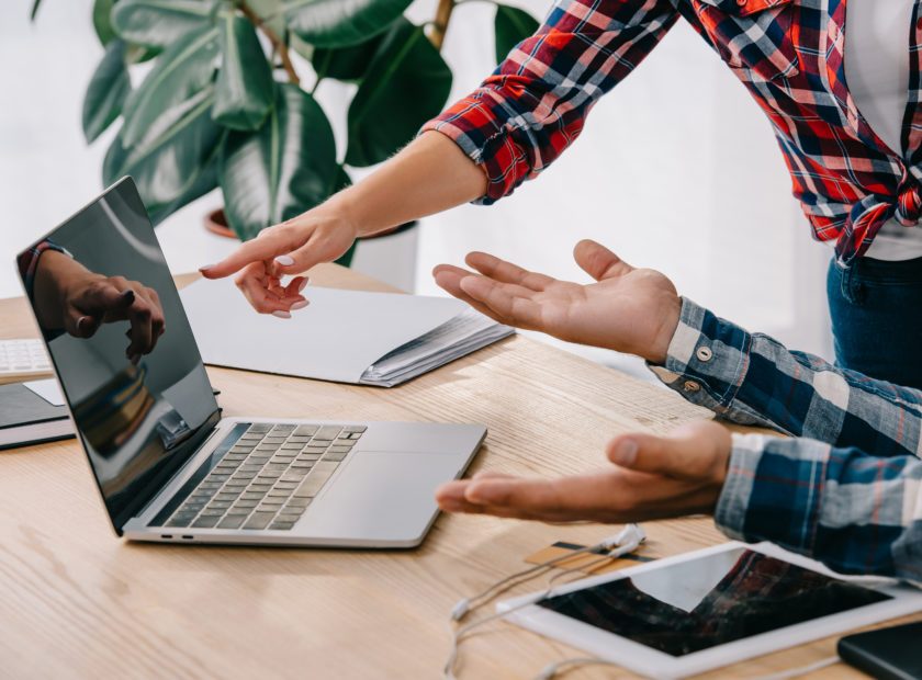 partial view of businesswoman pointing at blank laptop screen while taking part in webinar together