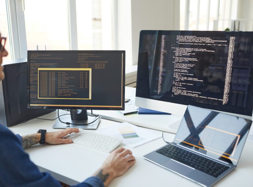 IT Programmer Writing Code on Computer Screen