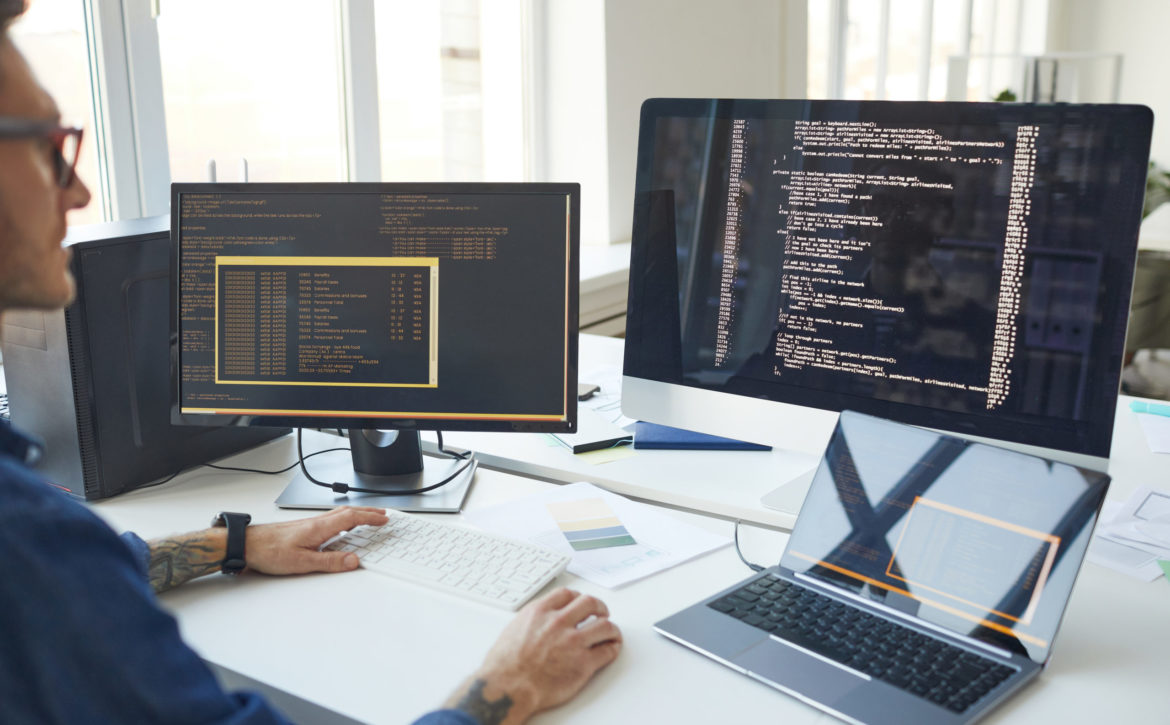 IT Programmer Writing Code on Computer Screen